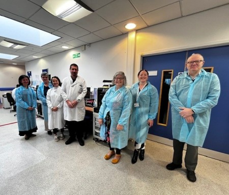 Three patients stood with lab staff in front of a digital pathology scanner -.jpg