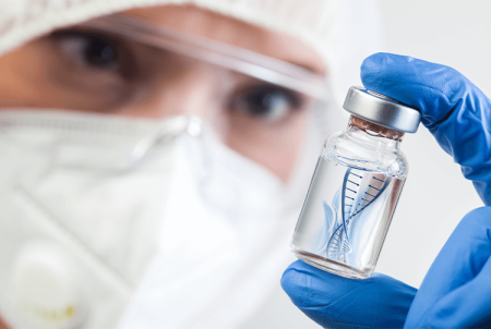 Photograph of a member of staff holding a vial of fluid